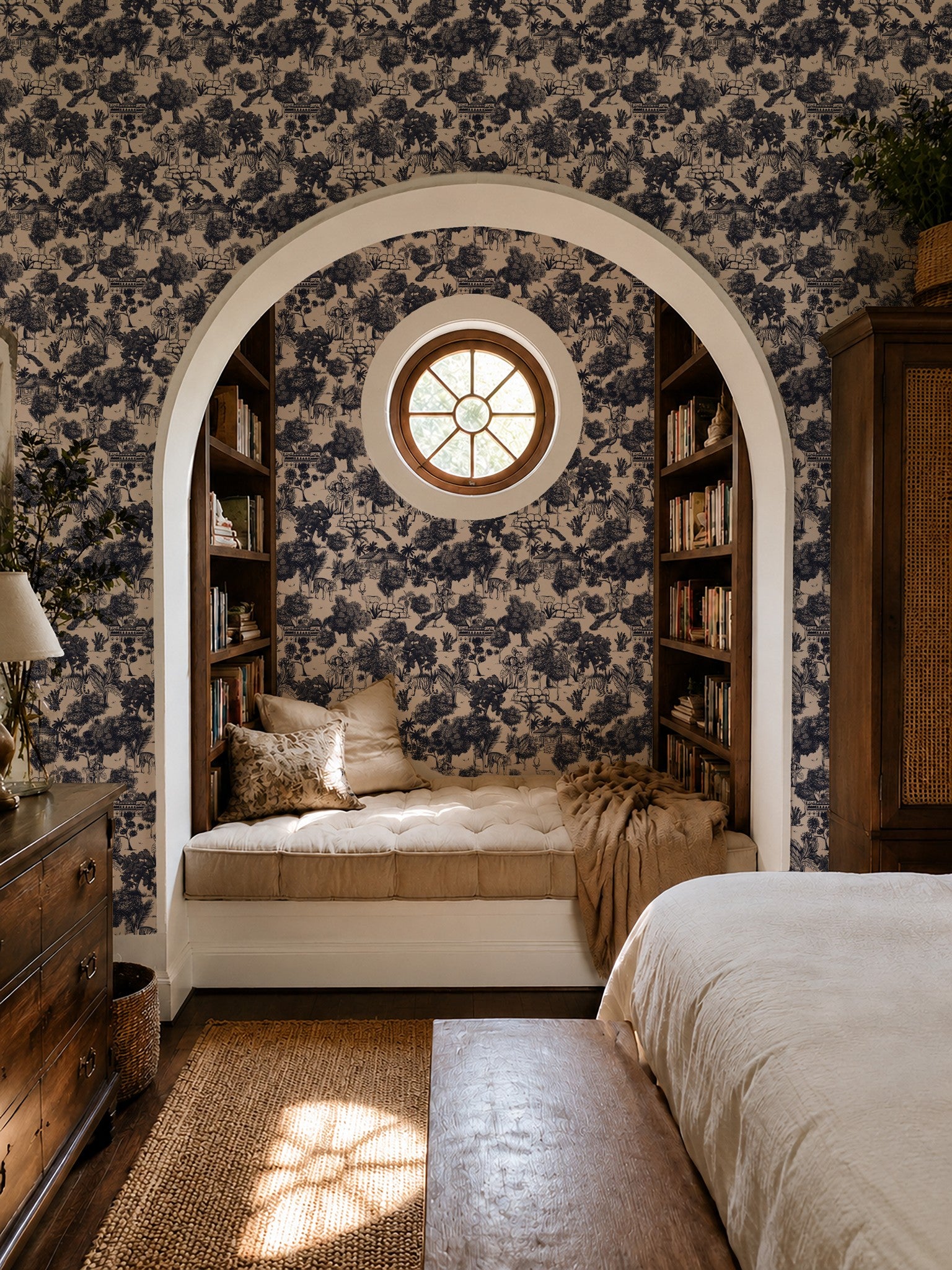 Blue jungle toile wallpaper in cozy bedroom with arched reading nook.