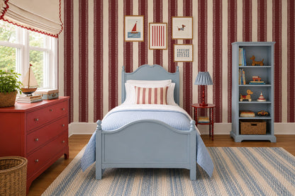 Burgundy lace stripe wallpaper in cozy bedroom with blue furniture.