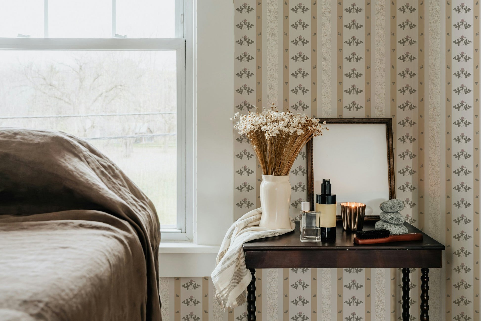Cream and mustard floral stripe wallpaper in cozy bedroom with vintage decor.