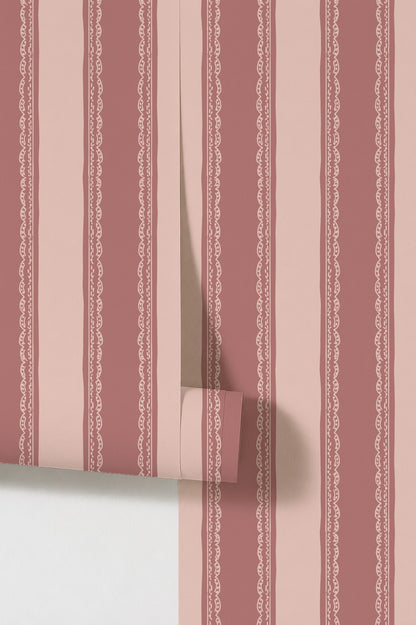 Dark pink striped wallpaper with lace detail.