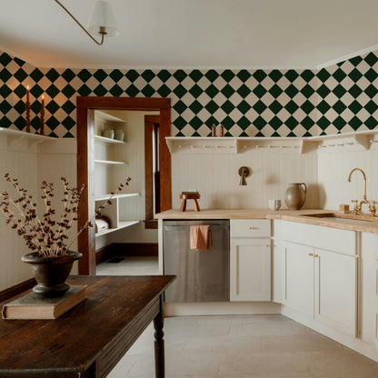Kitchen with Diamond Green wallpaper featuring forest green and cream diamond pattern above white cabinetry.