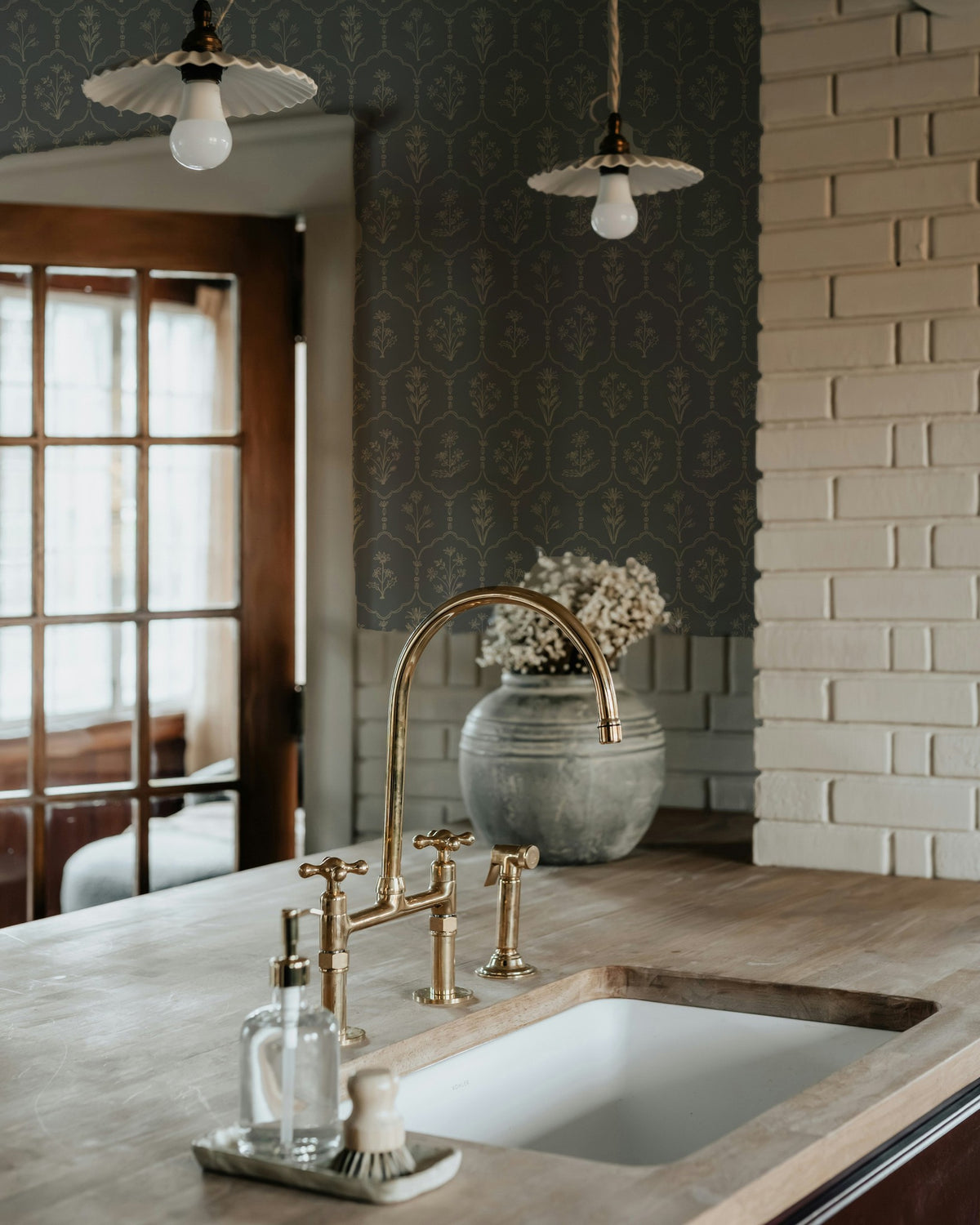 Floral trellis dusty blue wallpaper in rustic kitchen with brass fixtures.