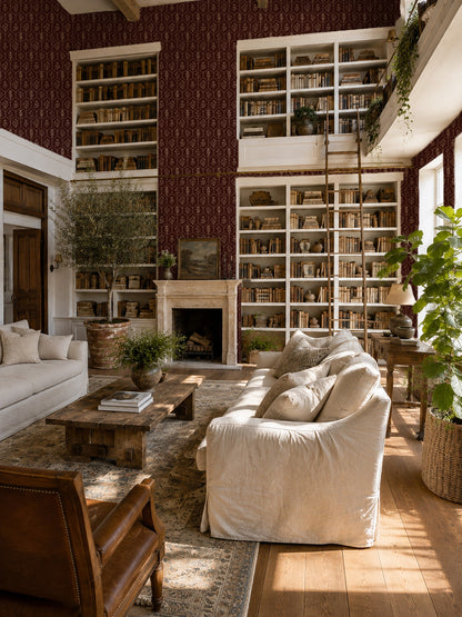 Living room with floral trellis red wallpaper, cream sofas, and wooden accents.