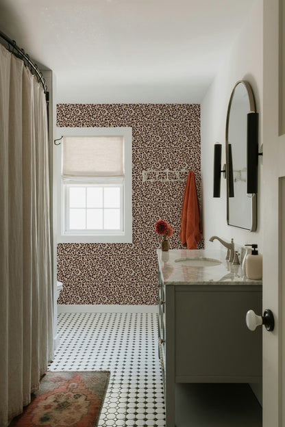 Leopard print cream wallpaper in modern bathroom with round mirror and patterned floor.