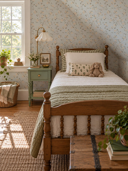 Light blue wallpaper with cream roses and hummingbirds in a vintage bedroom setting.