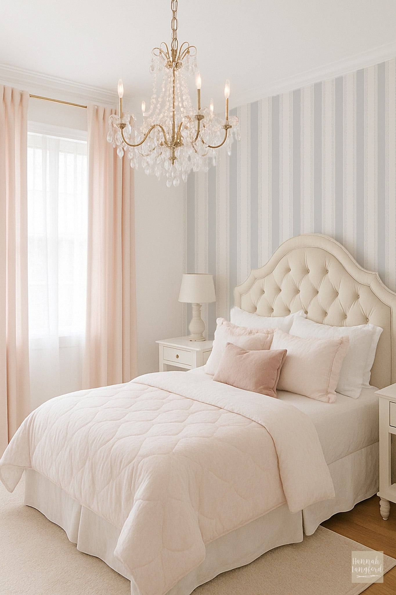 Light blue striped wallpaper in elegant bedroom with chandelier and tufted headboard.