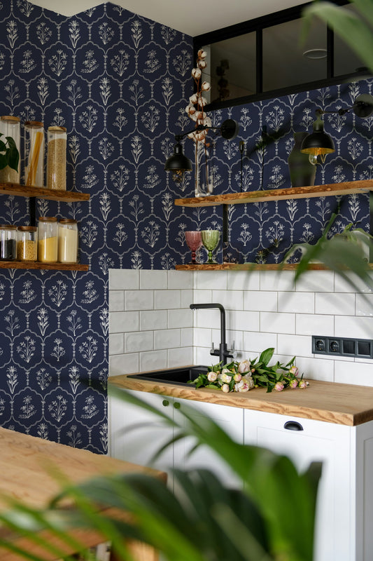 Navy floral trellis wallpaper in modern kitchen with wooden shelves and plants.
