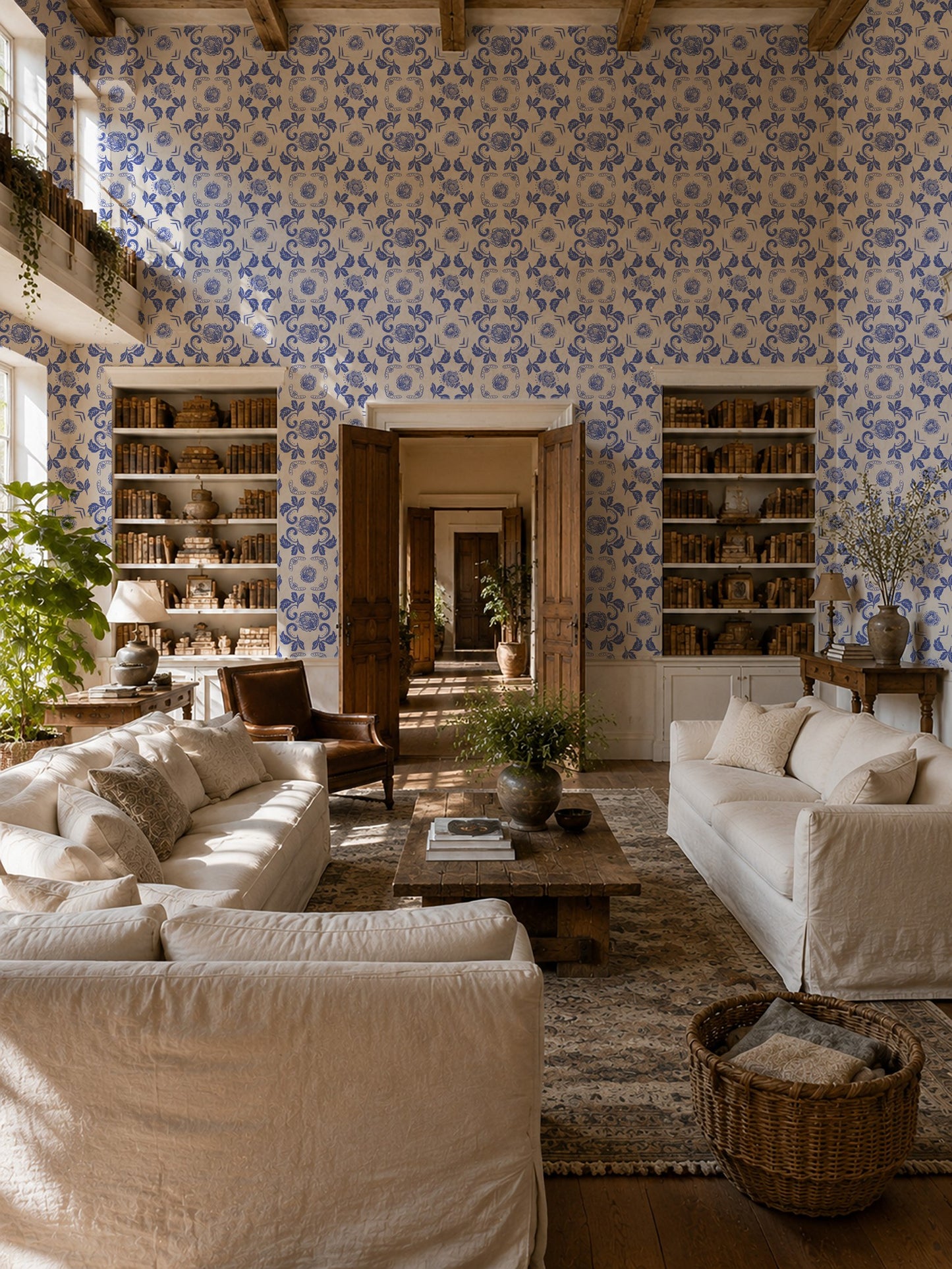 Nora Delft Blue floral wallpaper in cozy living room with cream sofas and rustic decor.