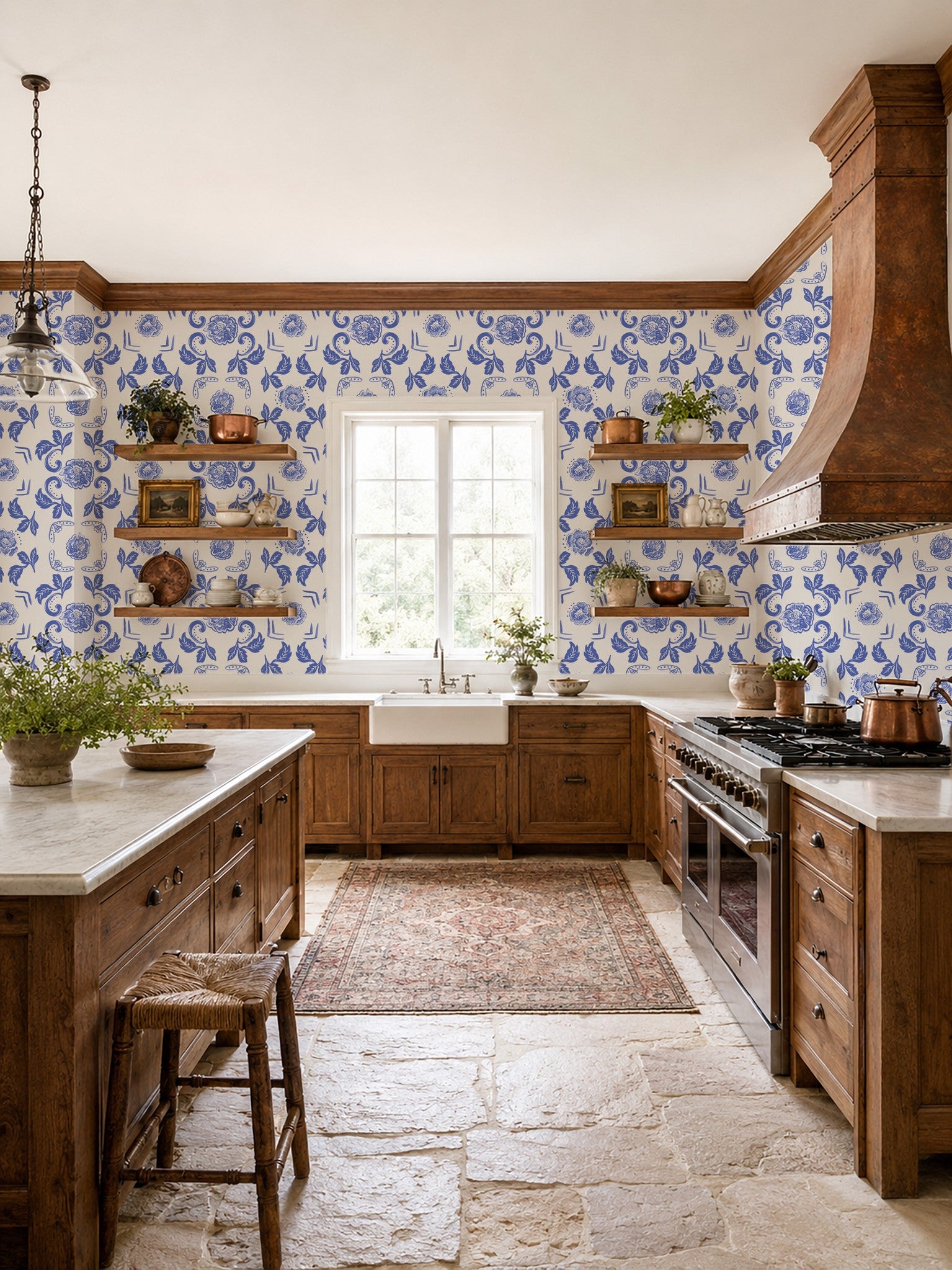 Kitchen with Nora Delft Blue floral wallpaper, rustic wood cabinets, and stone floor.