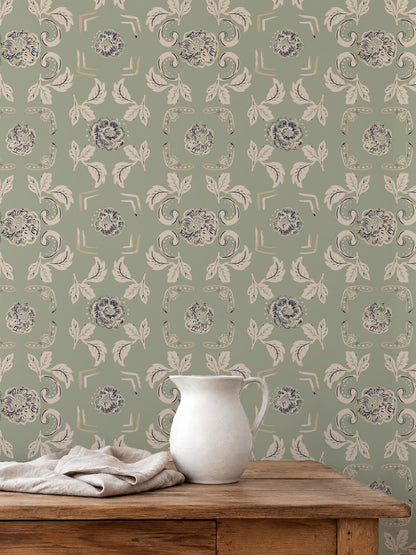 Nora Delft Green wallpaper with floral motifs in a rustic room setting.