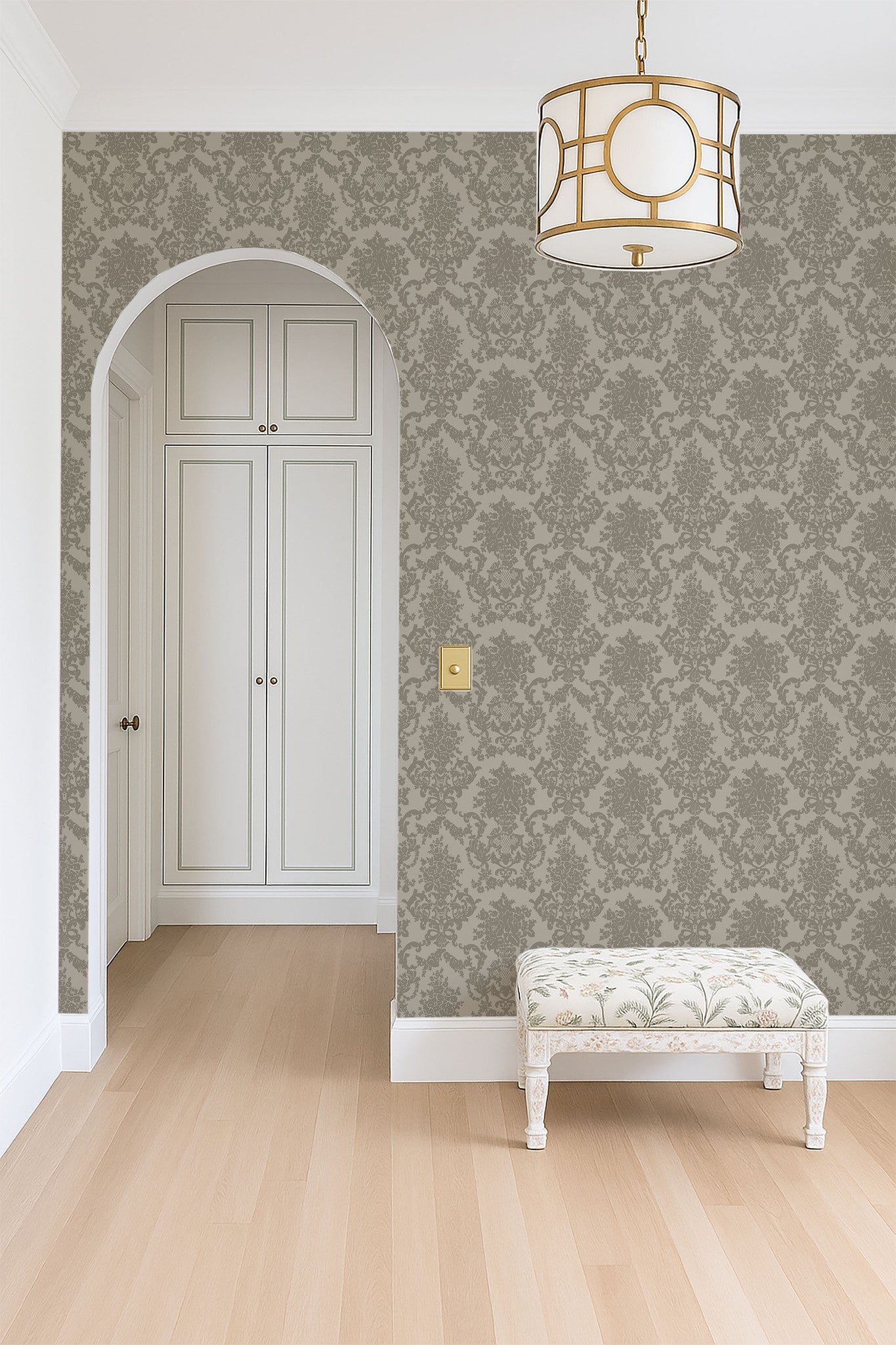 Olive green damask wallpaper in elegant hallway with arch and vintage bench.