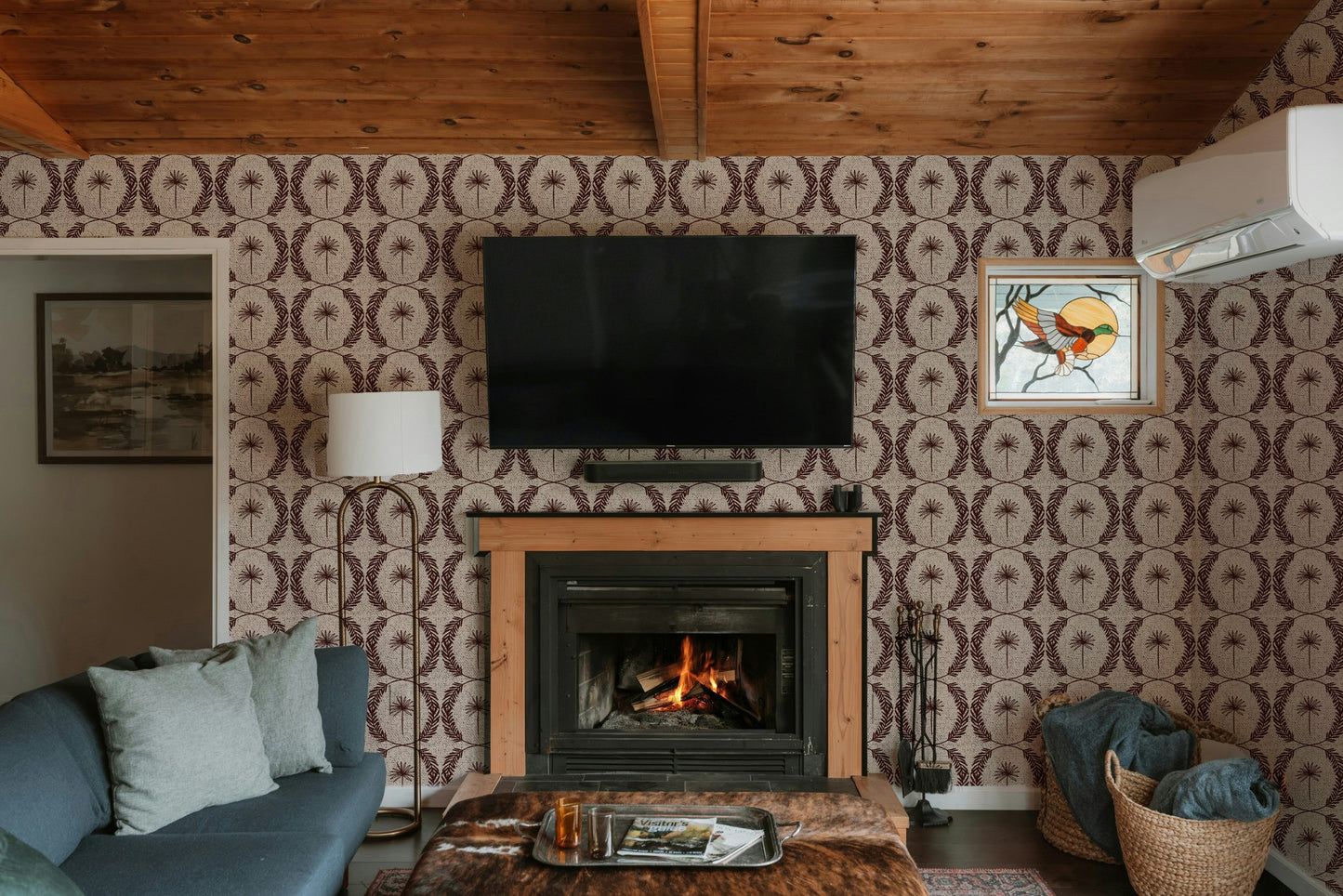 Living room with Palm Wreath Red wallpaper, fireplace, and cozy decor.