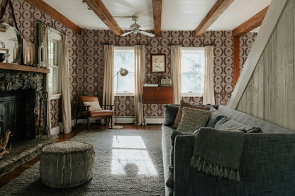 Living room with Palm Wreath Red wallpaper, deep mahogany on beige, rustic decor.