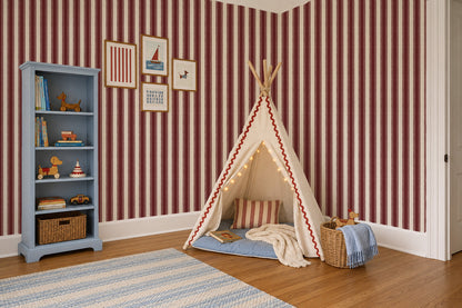 Red and cream striped wallpaper in a cozy children's room with a play tent.