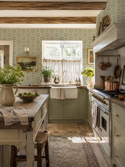Sage green floral wallpaper in a rustic kitchen with wooden beams and vintage decor.