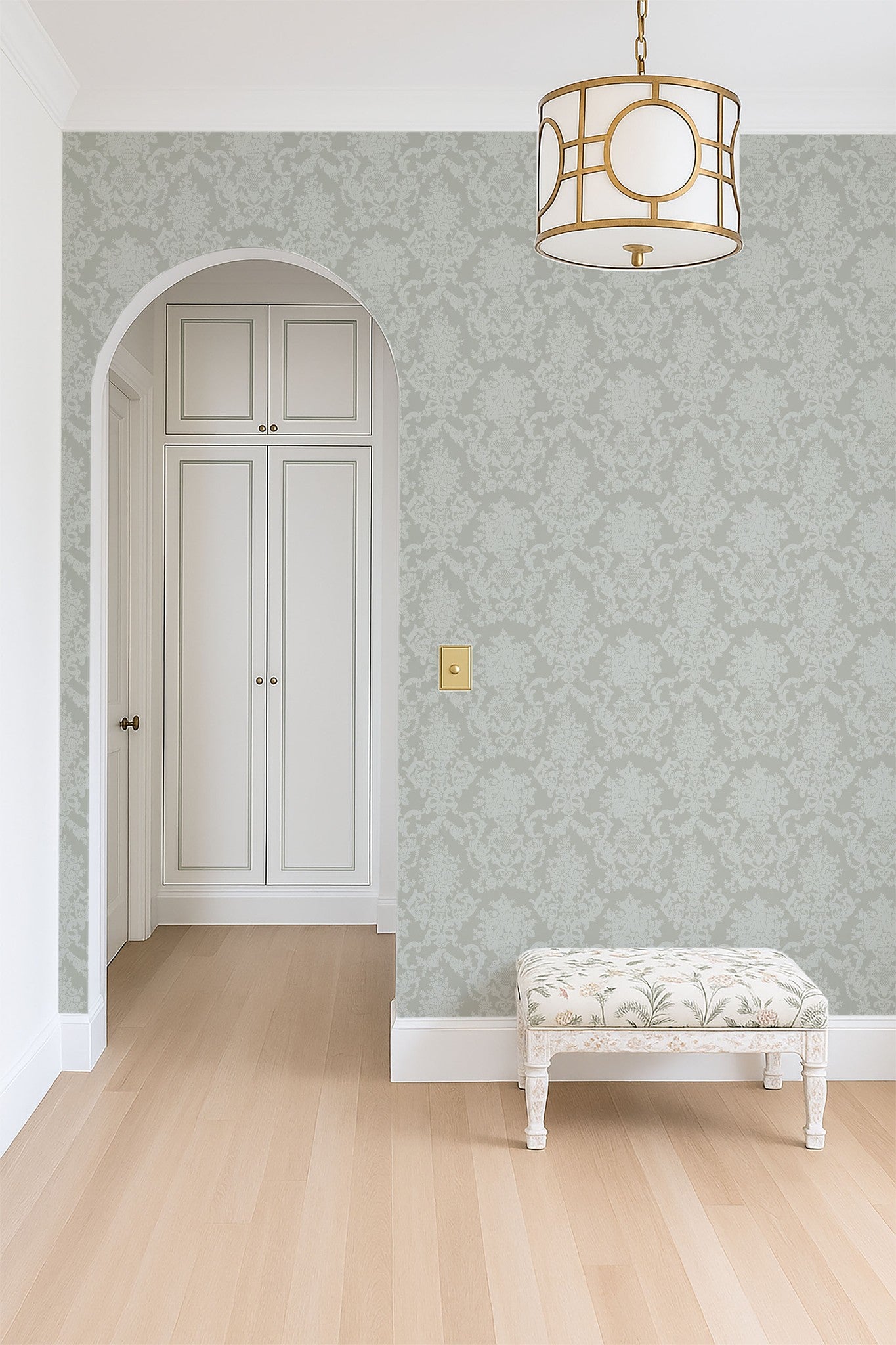 Sage neutral damask wallpaper in elegant room with archway and bench.