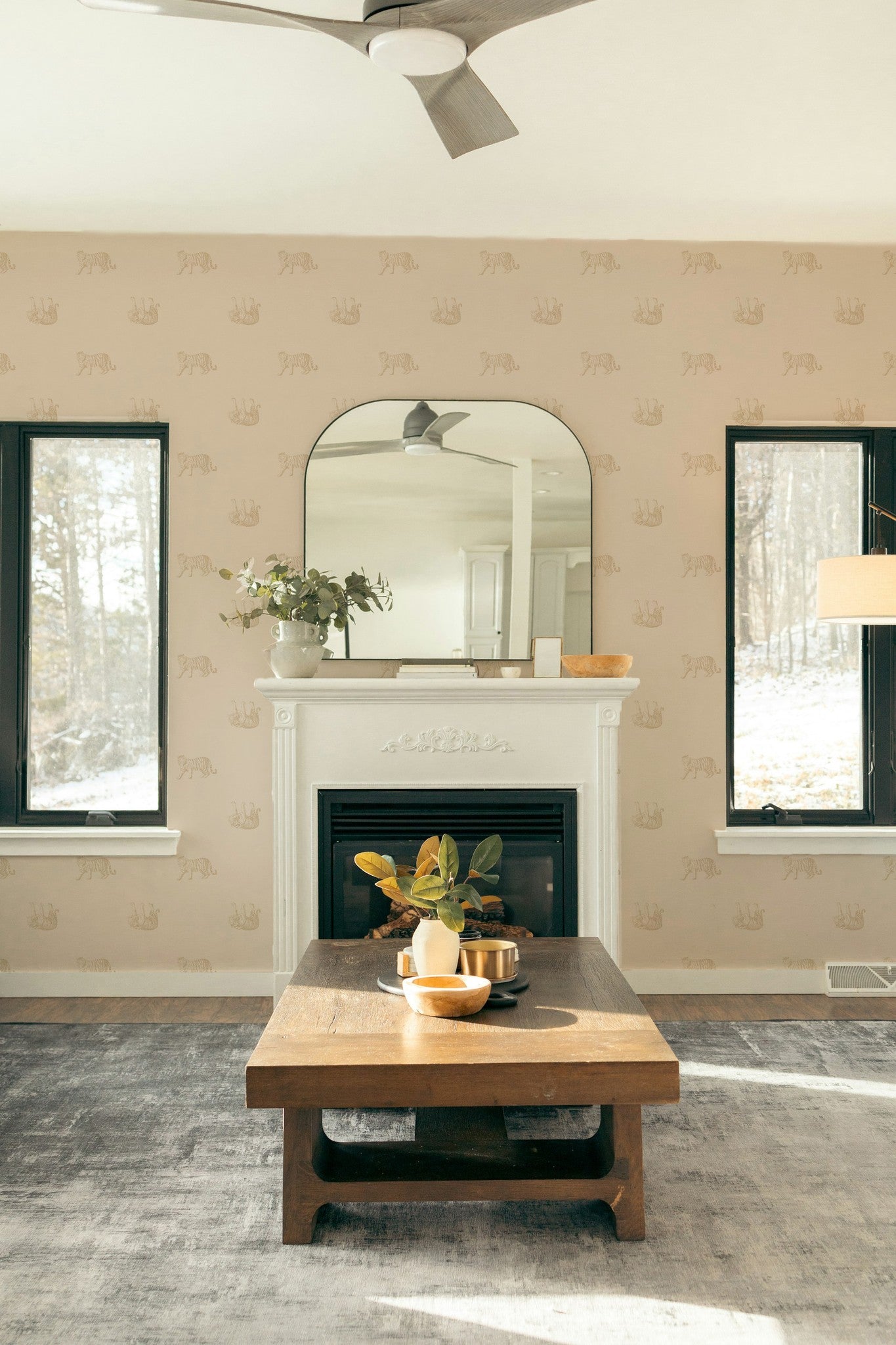 Living room with Tiger Cream wallpaper featuring sepia tigers on beige, white fireplace, and wooden coffee table.
